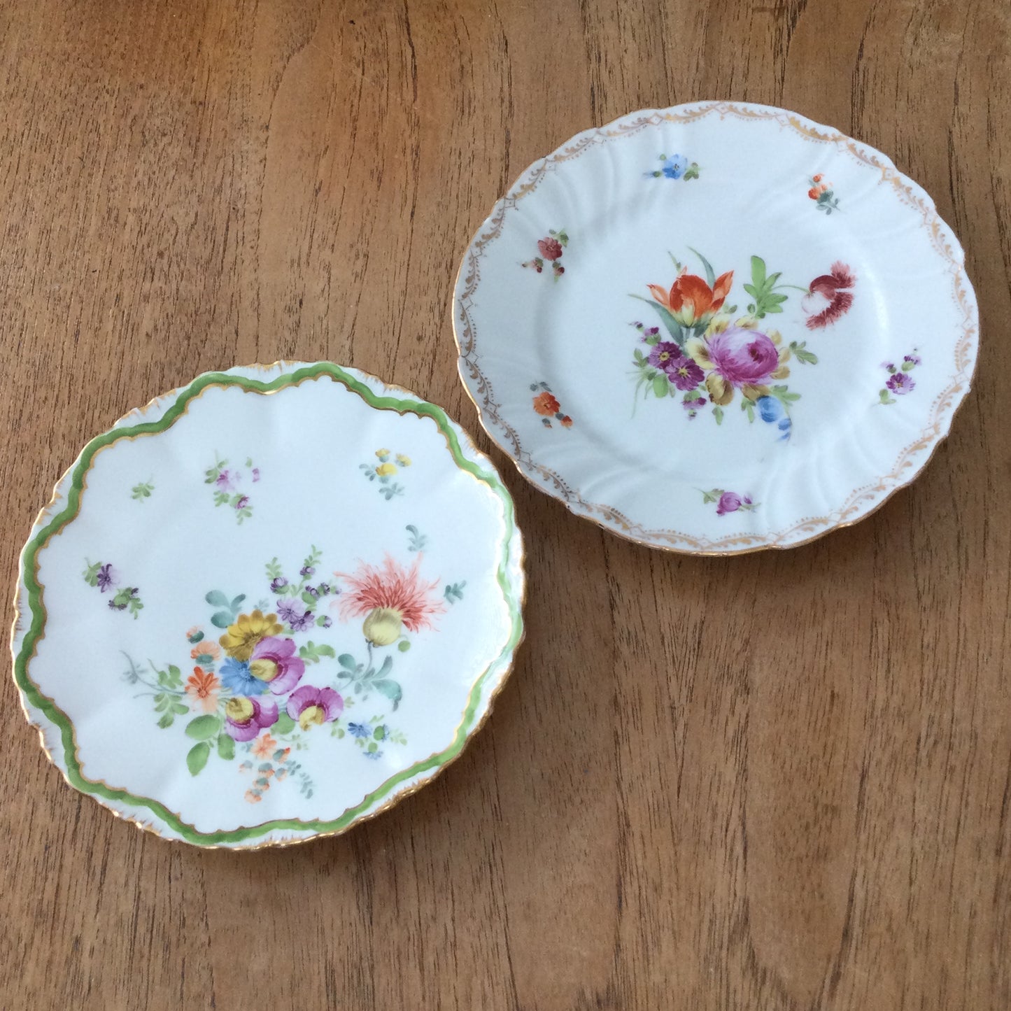 Pair of pretty hand-painted Dresden plates. Fancy gilt edges, with floral centre. Brightly coloured.