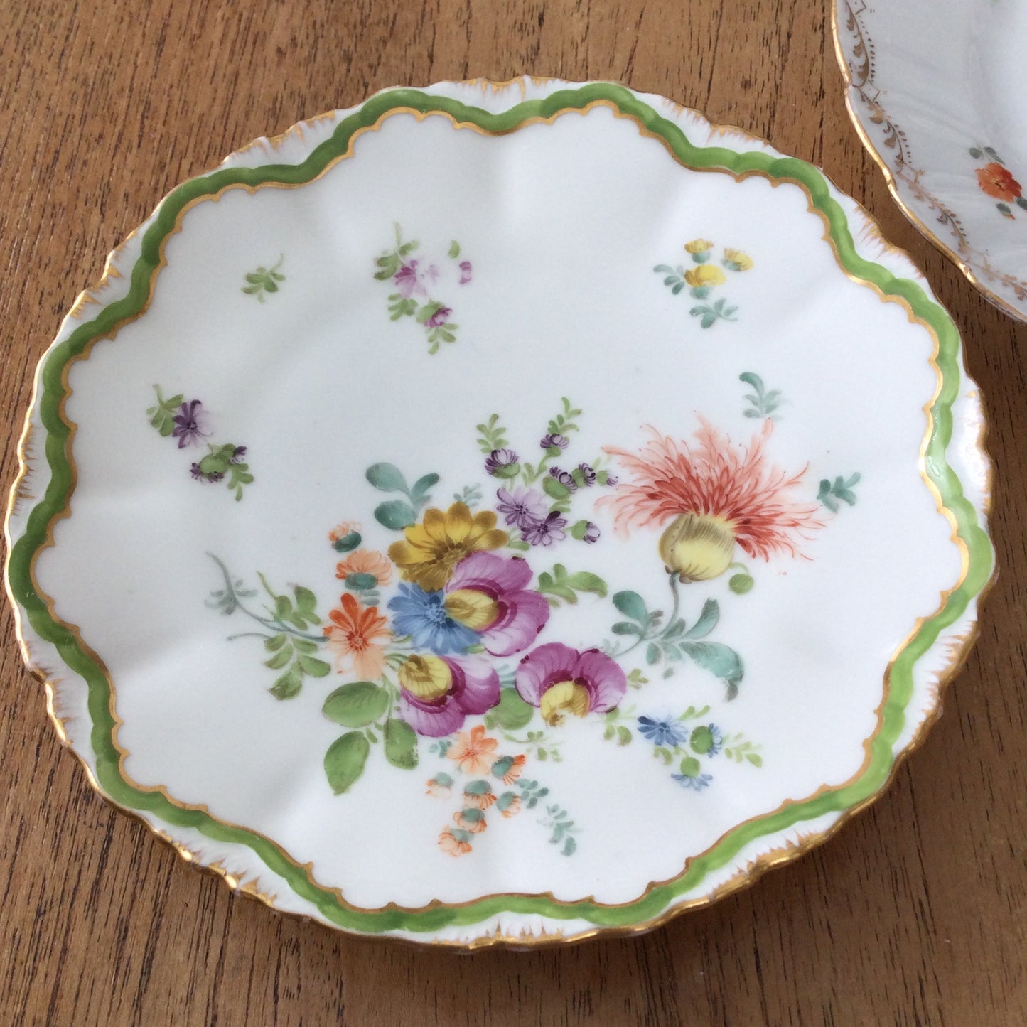 Pair of pretty hand-painted Dresden plates. Fancy gilt edges, with floral centre. Brightly coloured.