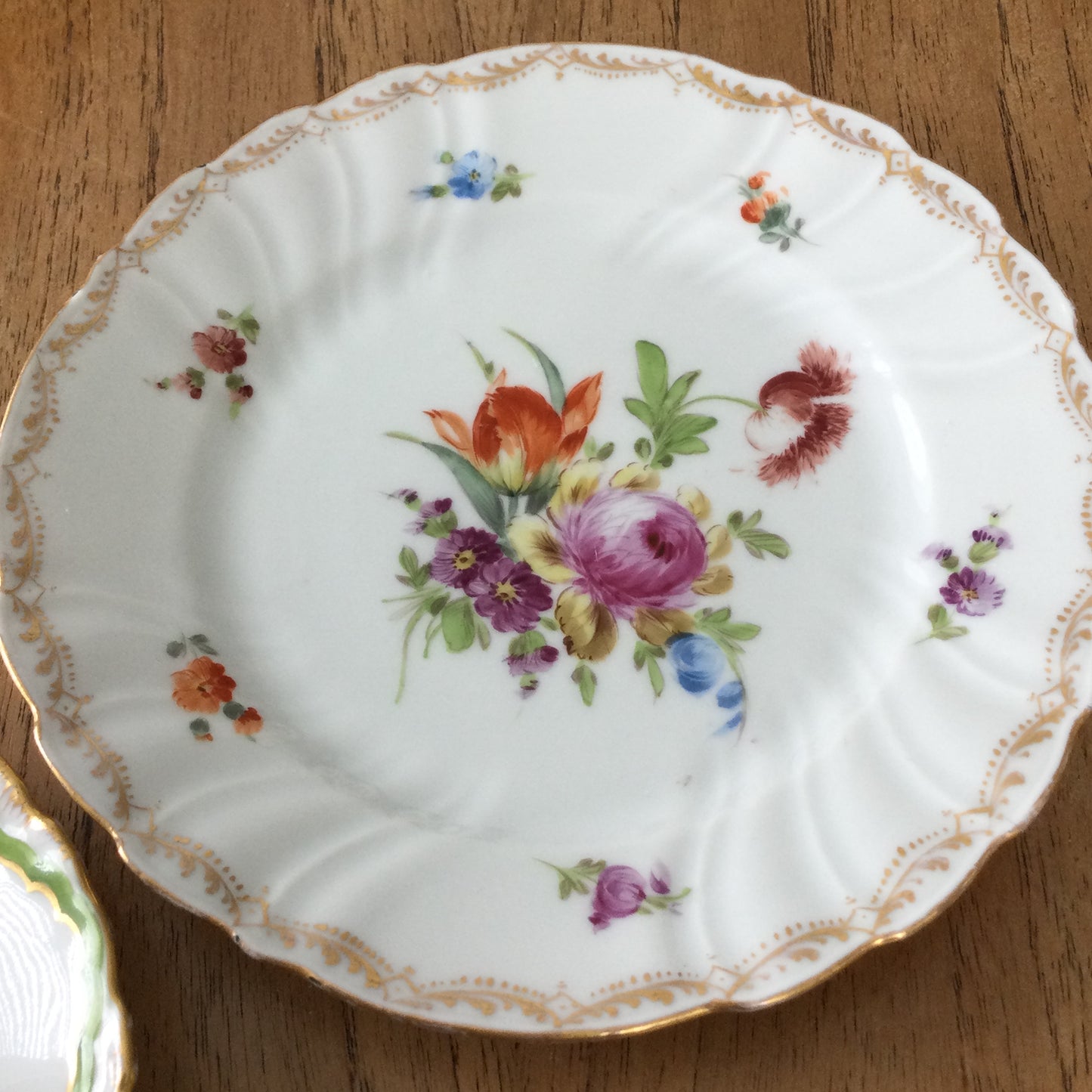 Pair of pretty hand-painted Dresden plates. Fancy gilt edges, with floral centre. Brightly coloured.