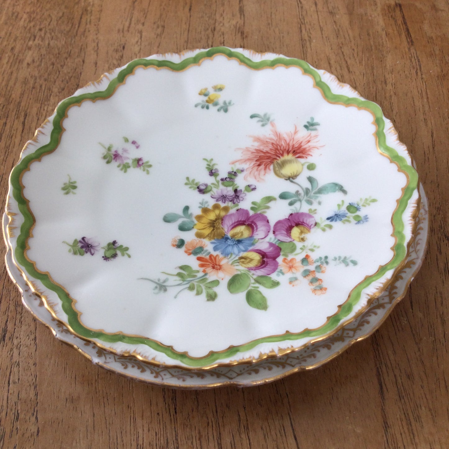 Pair of pretty hand-painted Dresden plates. Fancy gilt edges, with floral centre. Brightly coloured.