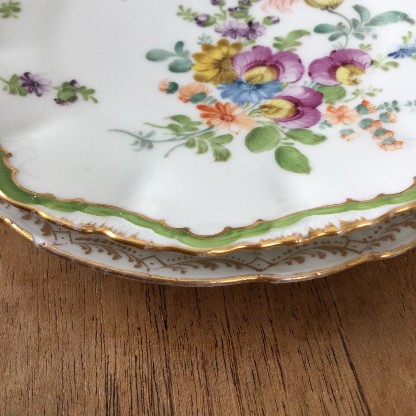 Pair of pretty hand-painted Dresden plates. Fancy gilt edges, with floral centre. Brightly coloured.
