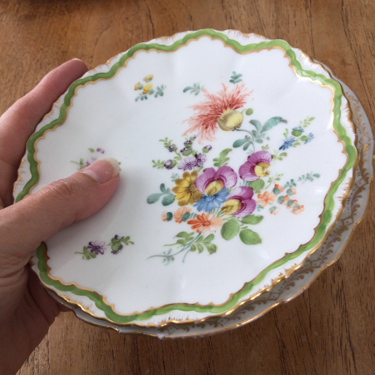 Pair of pretty hand-painted Dresden plates. Fancy gilt edges, with floral centre. Brightly coloured.