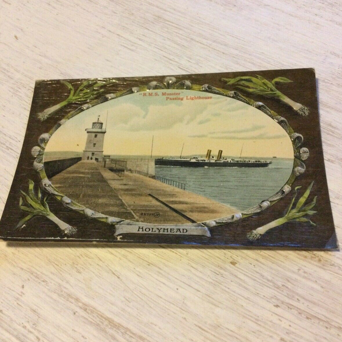 Vintage Embossed Postcard - WALES - Holyhead - RMS Munster Passing Lighthouse - Leek Border - Wales
