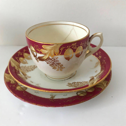 Festive bone china trio- cup, saucer, side plate. Deep pink & gold CRACKED CUP
