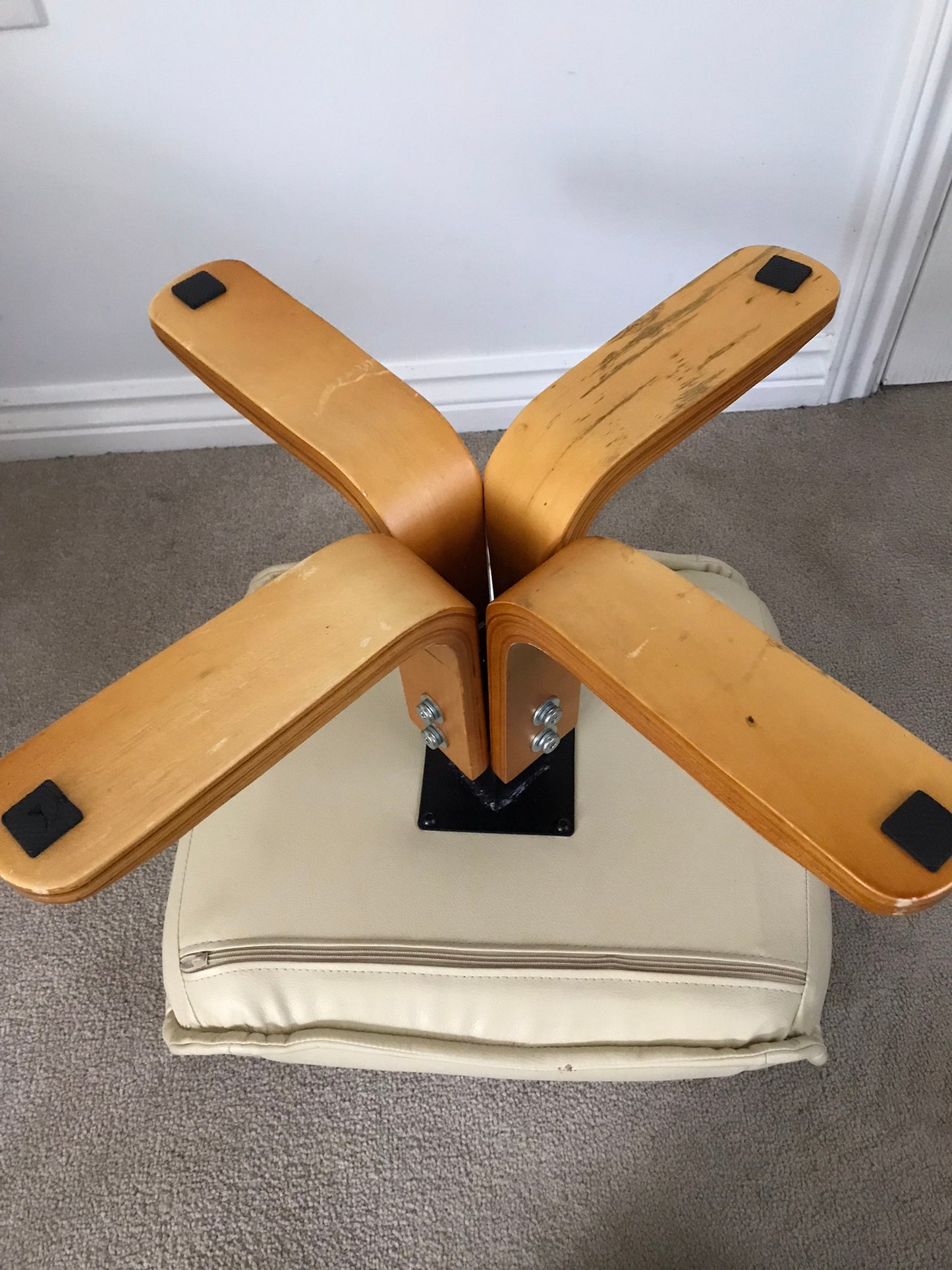 Cream faux leather footstool with wooden legs to match recliner chair.