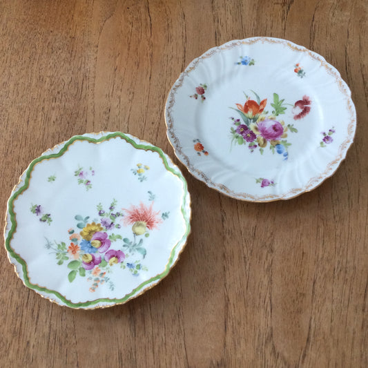 Pair of pretty hand-painted Dresden plates. Fancy gilt edges, with floral centre. Brightly coloured.