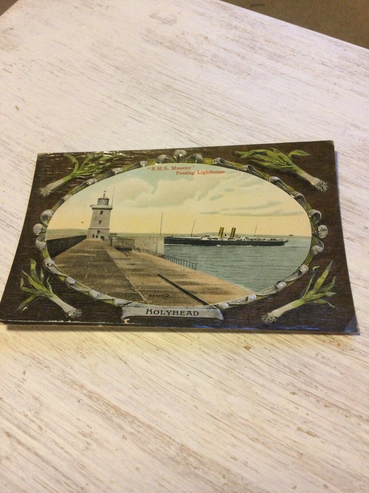 Vintage Embossed Postcard Holyhead. RMS Munster Passing Lighthouse. Leeks. Wales